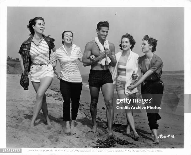 Gia Scala, Marianne Koch, George Nader, Julie Adams, and Elsa Martinelli walking down beach in publicity portrait the film 'Four Girls In Town', 1957.