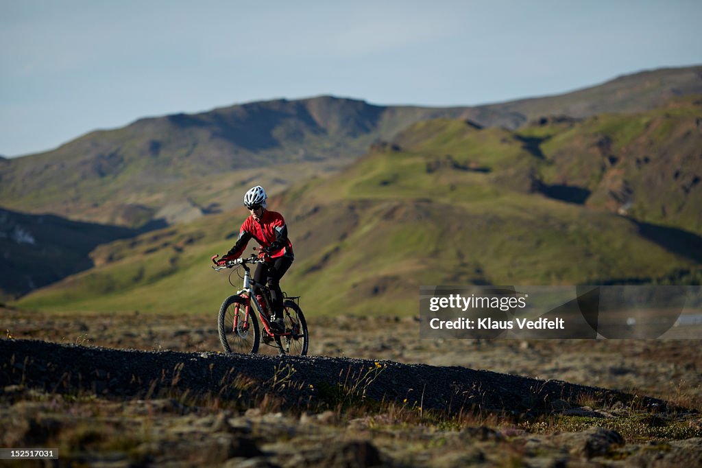 Man mountainbiking up hill off-road trail