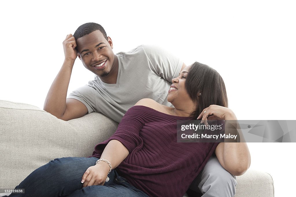 Smiling mother and son sitting on a couch.