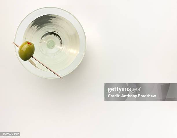a martini served with a stuffed olive - martini stockfoto's en -beelden