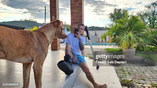 fractured tattooed man photographing his happy dog - indian crutch stock pictures, royalty-free photos & images