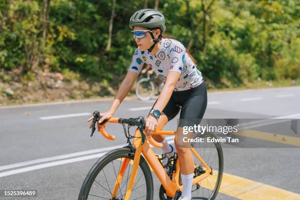 asian chinese female cyclist focus in rural cycling event - pursuit sports competition format stock pictures, royalty-free photos & images