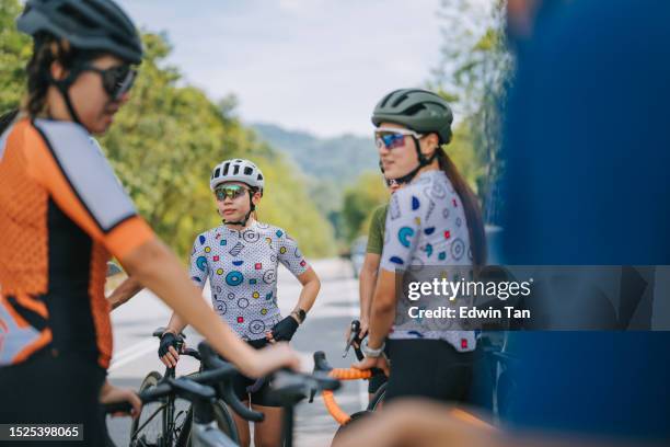 asiatische chinesische frauen rennradfahrer, die sich morgens an der ländlichen szene am strassenrand ausruhen - cycling team stock-fotos und bilder