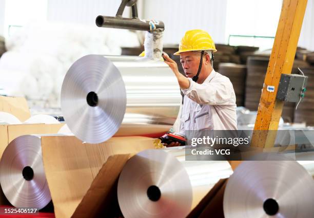 An employee works on the production line of aluminum foil at a workshop of Anhui Limu New Material Technology Co., Ltd on July 8, 2023 in Suixi...