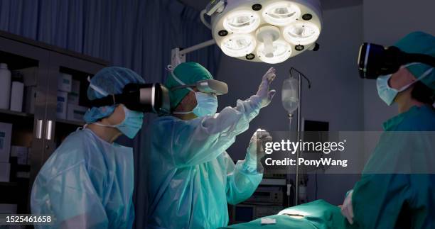 surgeons in hospital operating room - virtual stock pictures, royalty-free photos & images