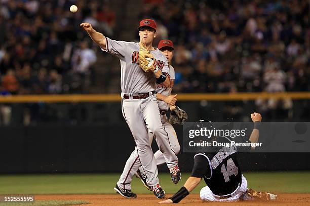 Second baseman Aaron Hill of the Arizona Diamondbacks turns a double play on Josh Rutledge of the Colorado Rockies on a grounder by Jordan Pacheco of...