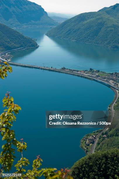 high angle view of lake and mountains against sky,lugano,switzerland - lugano stock-fotos und bilder