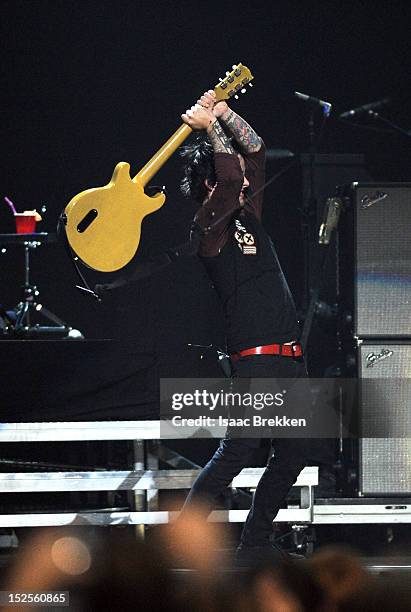 Frontman Billie Joe Armstrong of Green Day smashes his guitar as he performs onstage during the 2012 iHeartRadio Music Festival at the MGM Grand...