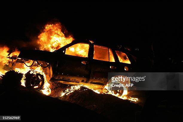 Vehicles burn after armed Libyan demonstrators stormed the headquarters of the Raf Allah al-Sahati Brigade, a local militia, located at a farm in the...