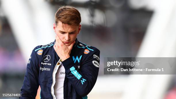 14th placed qualifier Logan Sargeant of United States and Williams walks in the Pitlane during qualifying ahead of the F1 Grand Prix of Great Britain...