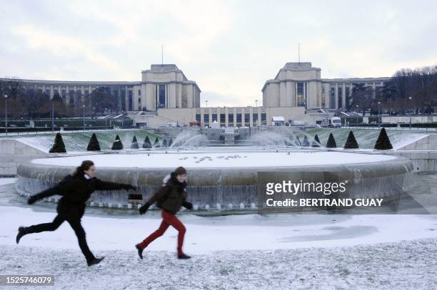 People run near a snow-covered and iced fountain at the Trocadero gardens on January 7, 2010 in Paris, as Europe shivered in bitterly cold...