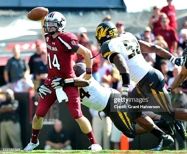 Quarterback Connor Shaw of the South Carolina Gamecocks throws under pressure from Sheldon Richardson and Michael Sam of the Missouri Tigers during...