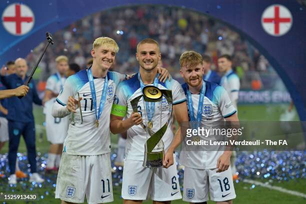 Anthony Gordon, Taylor Harwood-Bellis and Thomas Doyle of England pose with the trophy after winning the UEFA Under-21 Euro 2023 final match between...