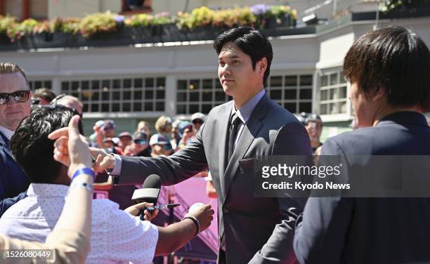 Shohei Ohtani of the Los Angeles Angels signs autographs at Major League Baseball's red carpet show ahead of the All-Star Game in Seattle on July 11,...