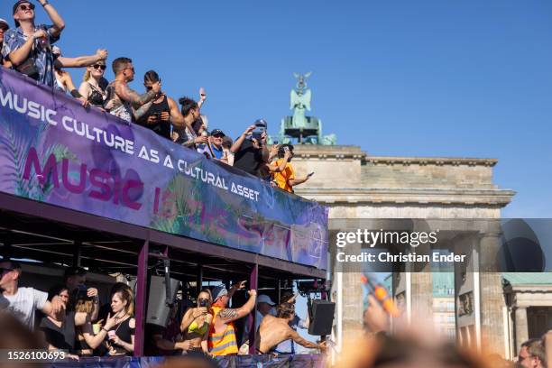 Techno music enthusiasts dance in front of the Brandenburg Gate on a music truck during the Rave the Planet parade in Tiergarten park on July 8, 2023...