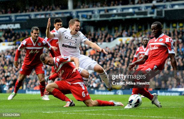 Gylfi Siggurdsson of Spurs is brought down by Clint Hill of QPR as he attempts to get a shot away during the Barclays Premier League match between...