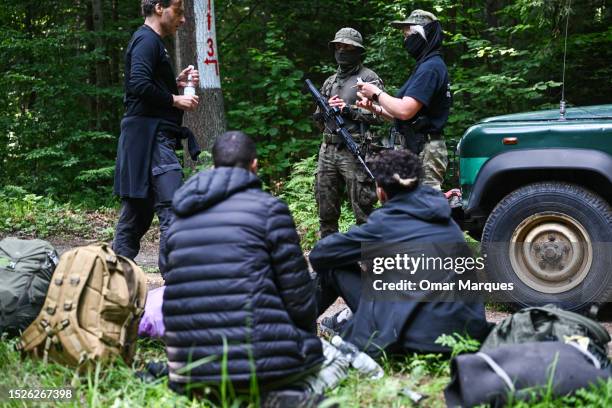 Bartek, a worker of Ocalenie Foundation speaks with Polish border guard about an asylum request as he represents migrants from Morocco who lived in...