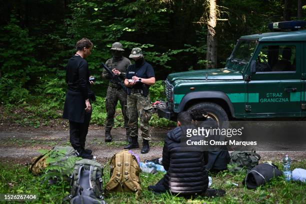 Bartek, a worker of Ocalenie Foundation speaks with Polish border guard about an asylum request as he represents migrants from Morocco who lived in...