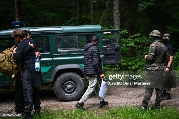 Migrants from Morocco who lived in the forest for 23 days and claimed to be pushed back to Belarus 3 times enter a Polish border guard vehicle as...