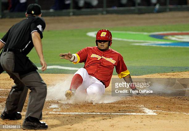 Jesus Golindano of Team Spain slides into home plate to score a run against Team France during game 2 of the Qualifying Round of the 2013 World...