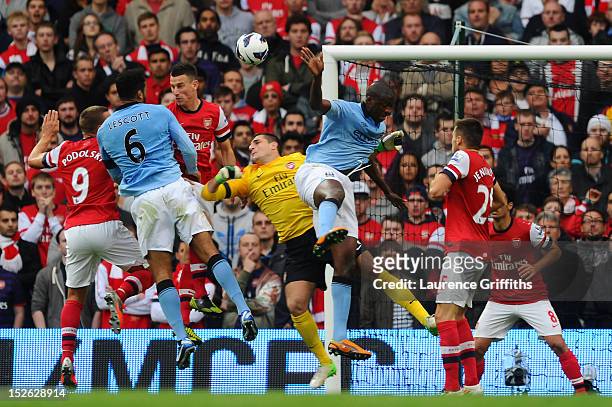 Joleon Lescott of Manchester City beats Vito Mannone of Arsenal to the ball to score the first goal during the Barclays Premier League match between...
