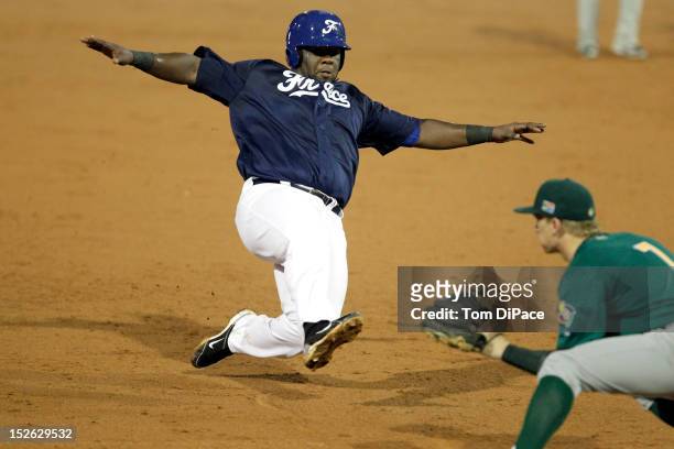 Rene Leveret of Team France slides safely into third base as Jonathan Phillips of Team South Africa applies the tag during game 4 of the Qualifying...