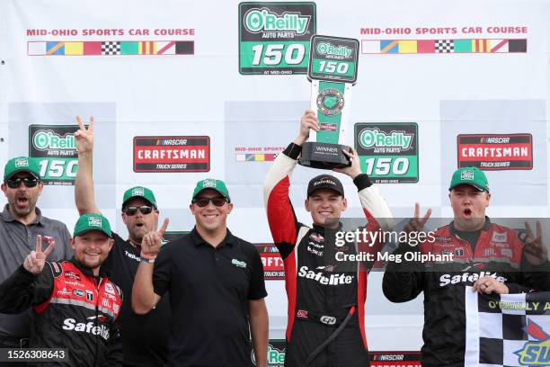 Corey Heim, driver of the Safelite Toyota, and crew celebrate in victory lane after winning the NASCAR Craftsman Truck Series O'Reilly Auto Parts 150...