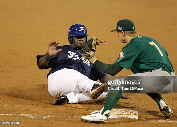 Rene Leveret of Team France slides safely into third base as Jonathan Phillips of Team South Africa applies the tag during game 4 of the Qualifying...