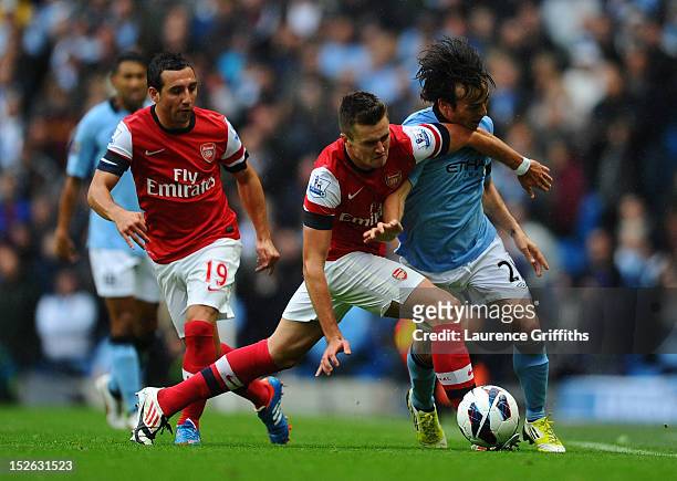 Carl Jenkinson of Arsenal clashes with David Silva of Manchester City during the Barclays Premier League match between Manchester City and Arsenal at...