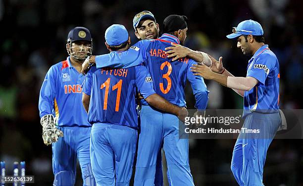 Indian bowler Harbhajan Singh is congratulated by team players after dismissal of England batsman Jos Buttler during the ICC T20 World Cup cricket...