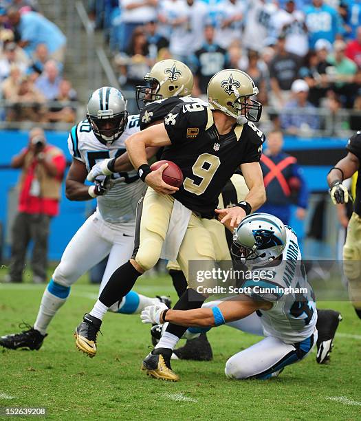 Drew Brees of the New Orleans Saints passes despite pressure by Haruki Nakamura of the Carolina Panthers at Bank of America Stadium on September 16,...