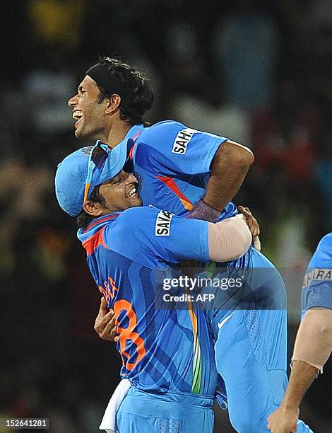 Indian cricketer Ashok Dinda celebrates with his teammate Suresh Raina after he dismissing unseen England captain Stuart Broad during the ICC...