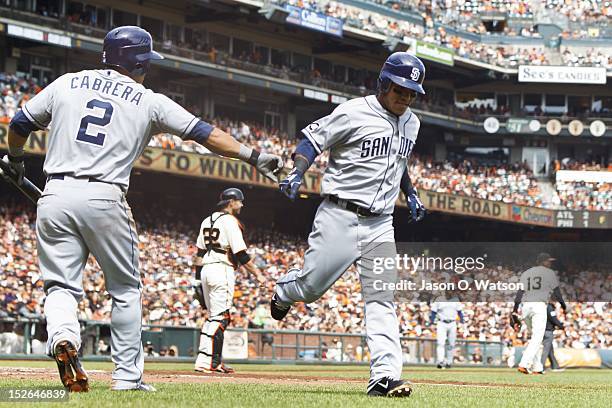 Alexi Amarista of the San Diego Padres is congratulated by Everth Cabrera after scoring a run against the San Francisco Giants during the second...