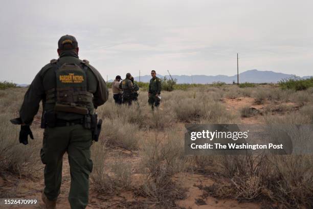 United States Border Patrol agents Sean Coffey, right, and Richard Barragan, far left, arrive to the scene where the body of a deceased migrant, far...