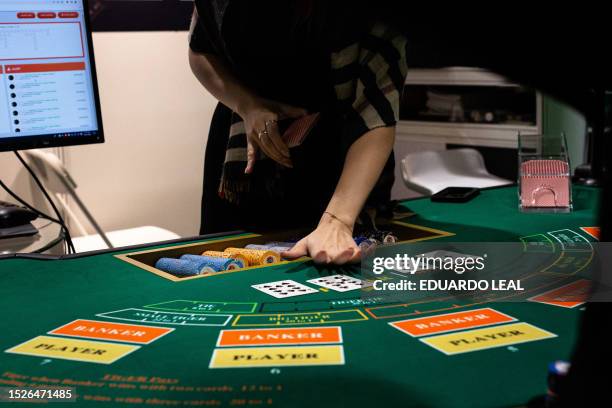 Demonstrator lays cards on a table during the Global Gaming Expo Asia at a casino in Macau on July 12, 2023.