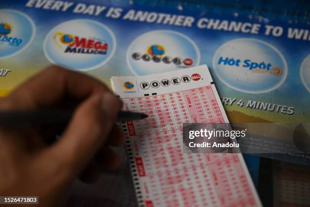 Person plays Powerball lottery at a gas station as giant Powerball and Mega Millions jackpots grow more than $1B combined, in Trona, California,...