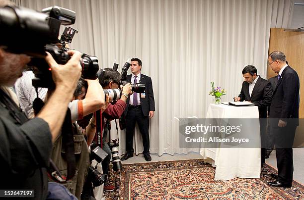 President of Iran Mahmoud Ahmadinejad signs a guest book as United Nations Secretary General Ban Ki-moon looks on before their meeting at United...