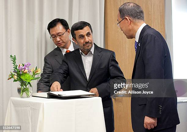 President of Iran Mahmoud Ahmadinejad signs a guest book as United Nations Secretary General Ban Ki-moon looks on before their meeting at United...