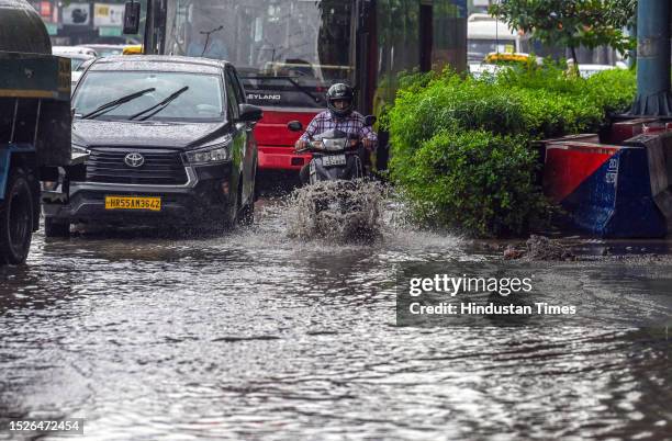 Commuters moves through a water logged street after heavy rains lashes out the city at ITO Vikash Marg on July 10, 2023 in New Delhi, India. Several...