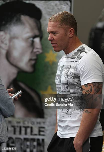 Current WBO Asia Pacific & Oriental Heavyweight Champion Shane Cameron stands face on to a poster of Danny Green as he talks to media at a press...