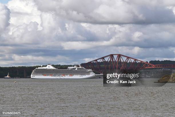 The Oceania cruise ship Riviera at anchor off the Forth Bridge, with the UK cruising season in full swing, on July 12, 2023 in Dalgety Bay, Scotland.