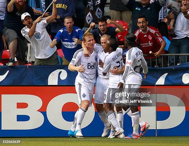 Barry Robson of the Vancouver Whitecaps FC hugs goal scorer Kenny Miller \while Dane Richards and Darren Mattocks join the celebration against the...