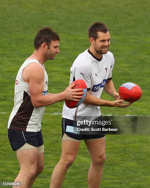 Luke Hodge and Brent Guerra of the Hawks pass the ball during a Hawthorn Hawks training session at Waverley Park on September 24, 2012 in Melbourne,...