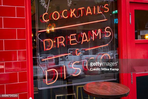 Cocktails and Dreams and Disco neon sign in the window of Simmons Bar in Soho on 9th July 2023 in London, United Kingdom. Soho is an area of the City...