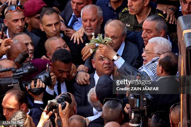 Palestinian president Mahmud Abbas arrives to lay a wreath of flowers by the graves of Palestinians killed in recent Israeli military raids on the...