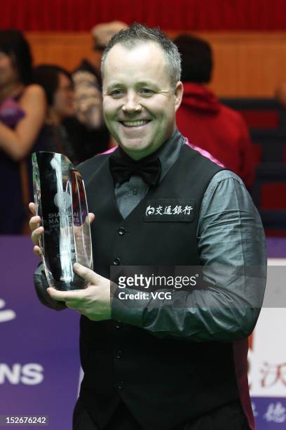 John Higgins of Scotland poses with the trophy after winning the final match against Judd Trump of England on day seven of the 2012 World Snooker...