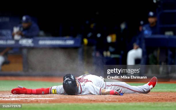 Orlando Arcia of the Atlanta Braves slides into home in the ninth inning during a game against the Tampa Bay Rays at Tropicana Field on July 08, 2023...