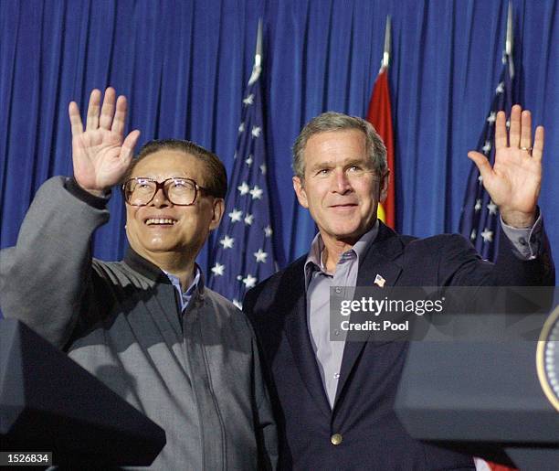 President George W. Bush and Chinese President Jiang Zemin wave following a joint news conference October 25, 2002 at the Bush ranch in Crawford,...