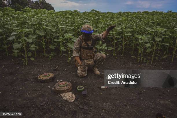 The leader of clearance team explains the operation as Ukrainian army's 35th Marine Brigade members conduct mine clearance work at a field in...