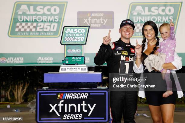 John Hunter Nemechek, driver of the Mobil 1 Toyota, celebrates with his wife, Taylor Nemechek, and daughter, Aspen Palmer Nemechek in victory lane...